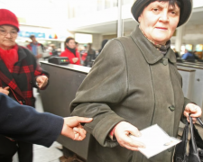 Жінка похилого віку тримає пенсійне посвідчення