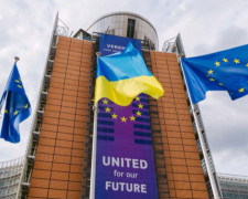 Український прапор на тлі будівлі Європейської комісії у Брюсселі, де обговорюють правила тимчасового захисту.