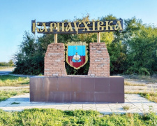 Герб селища Карнаухівка з козаком біля казана