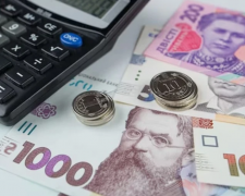Гривневі банкноти та розрахунковий листок із зарплатою