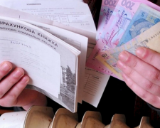 Літня людина заповнює документи на субсидію
