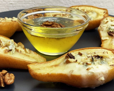 Запечені груші з медом, волоськими горіхами і корицею на тарілці