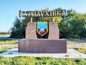Герб селища Карнаухівка з козаком біля казана