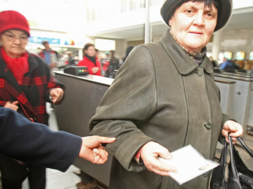 Жінка похилого віку тримає пенсійне посвідчення