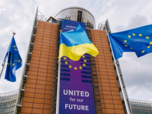 Український прапор на тлі будівлі Європейської комісії у Брюсселі, де обговорюють правила тимчасового захисту.