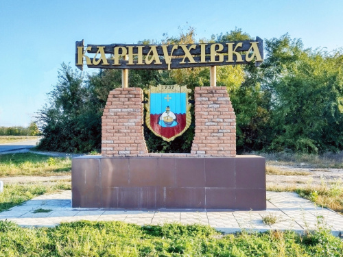 Герб селища Карнаухівка з козаком біля казана