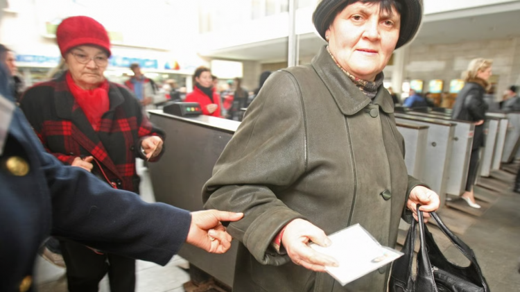 Жінка похилого віку тримає пенсійне посвідчення
