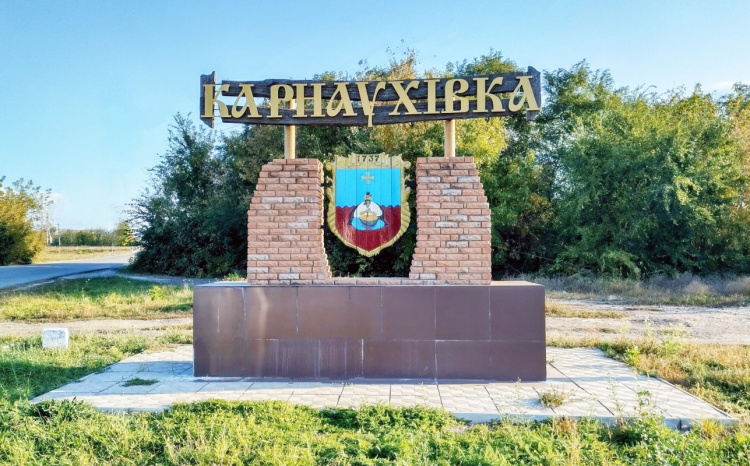 Герб селища Карнаухівка з козаком біля казана