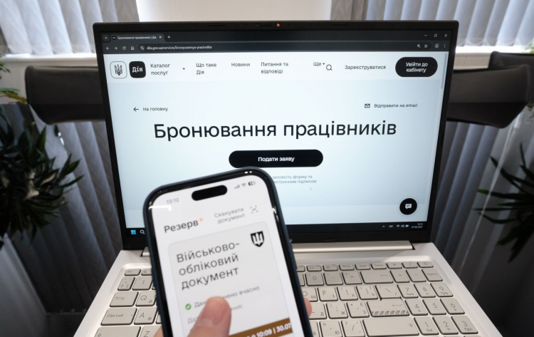 Чоловік у робочому кабінеті переглядає документи про бронювання співробітників підприємства на Дніпропетровщині.