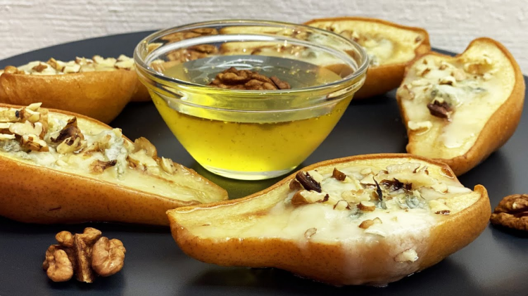 Запечені груші з медом, волоськими горіхами і корицею на тарілці